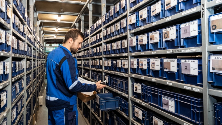 Técnico de taller Mercedes-Benz seleccionando repuesto original.