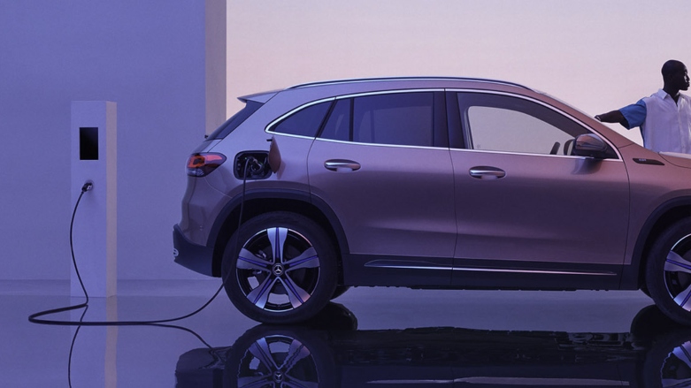 <p>SUV eléctrica Mercedes-Benz EQA color gris siendo cargada conectada a estación de carga eléctrica de autos.</p>